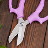 Purple precision shears with silver blades resting on a dark wooden surface.