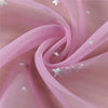 Pink tulle fabric with silver star embellishments is draped and swirling.