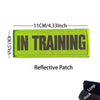 A bright lime green reflective patch embroidered with the text IN TRAINING