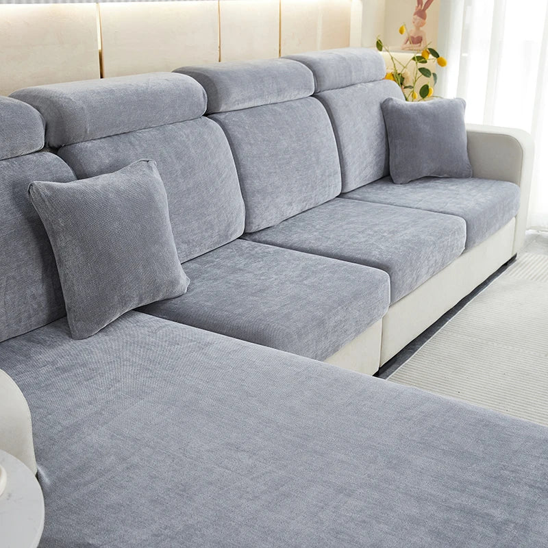 A light gray stretchable chenille sofa cushion cover with matching throw pillows on a modern sofa.