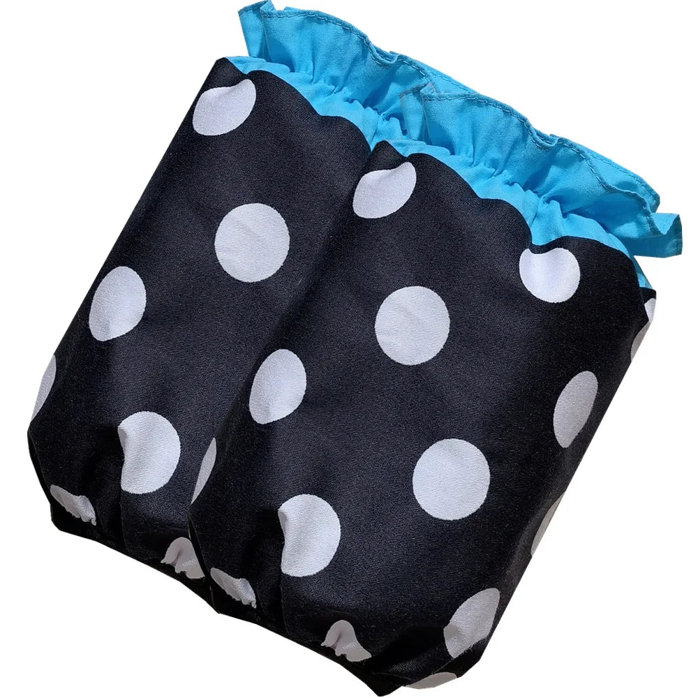 Black fabric apron with white polka dots and light blue ruffled trim and pockets