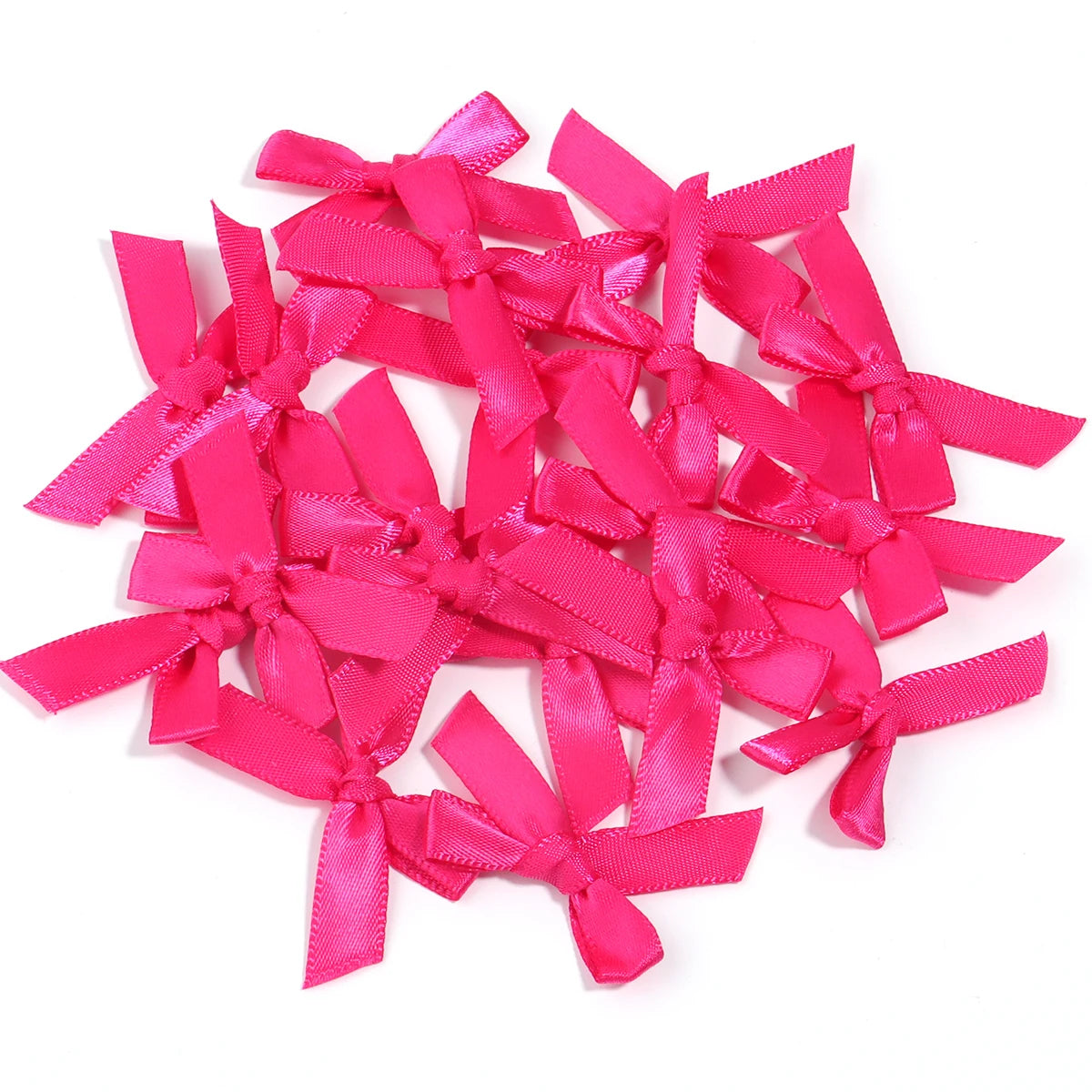 A pile of bright pink satin ribbon bows for craft and decoration.