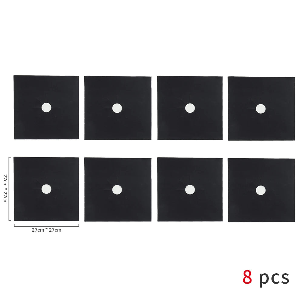 Eight black square gas stove protectors with white circular holes.
