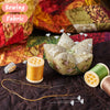 Transparent diamond pins for crafting are shown next to sewing fabric and a spool of thread.