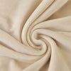 A close-up of a beige stretchy velvet bench slipcover fabric tightly rolled into a swirl.