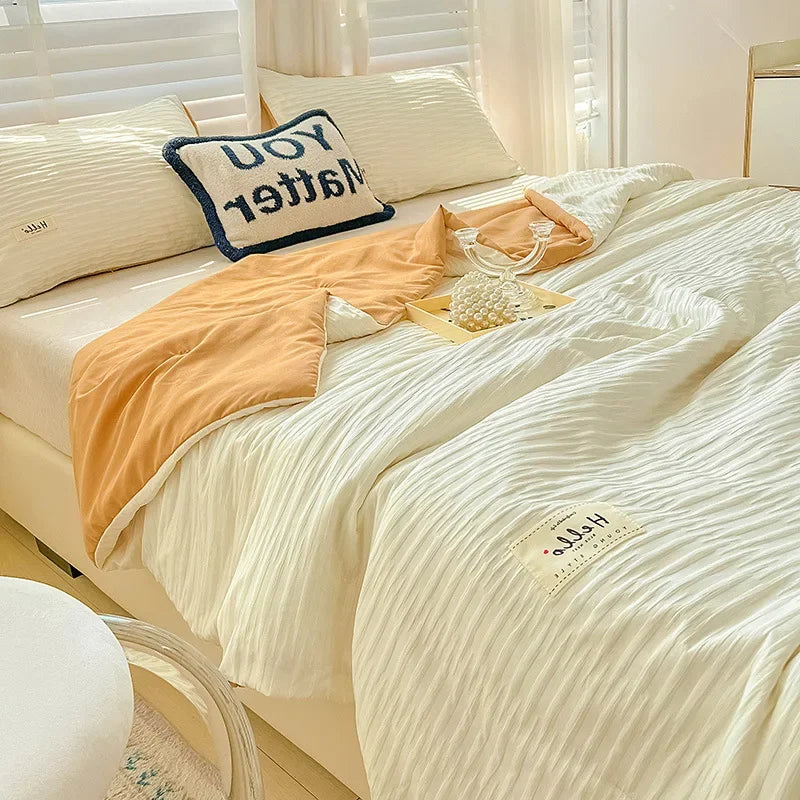A light beige Korean style seersucker summer quilt set with white stripes and accent pillows.