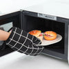 A hand wearing a black checkered oven glove is reaching into an open white kitchen oven to retrieve a food item.