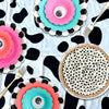 Pink and teal floral patterned disposable plastic tablecloths with black abstract shapes