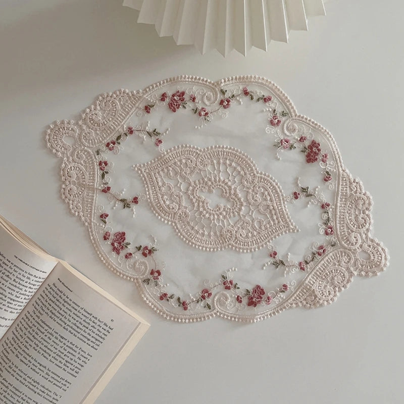 Elegant oval lace embroidered coaster set with pink floral details on a white background