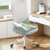 A white ergonomic memory foam seat cushion with a light green cover is shown on a wheeled office chair.