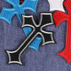 A set of multi-color cross embroidery patches featuring blue, red, and black designs on denim fabric.