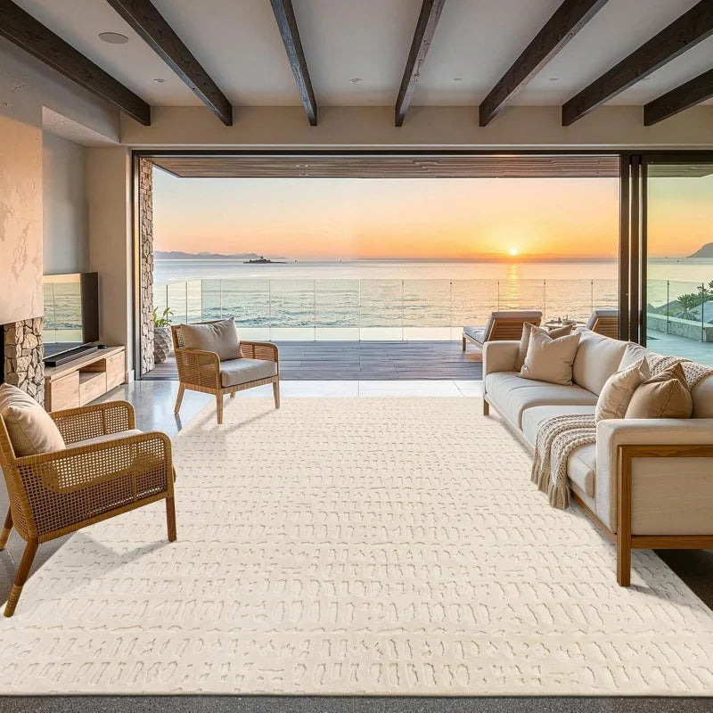 A large cream cowhide print area rug in a modern living space with wooden beams and a view of the ocean.