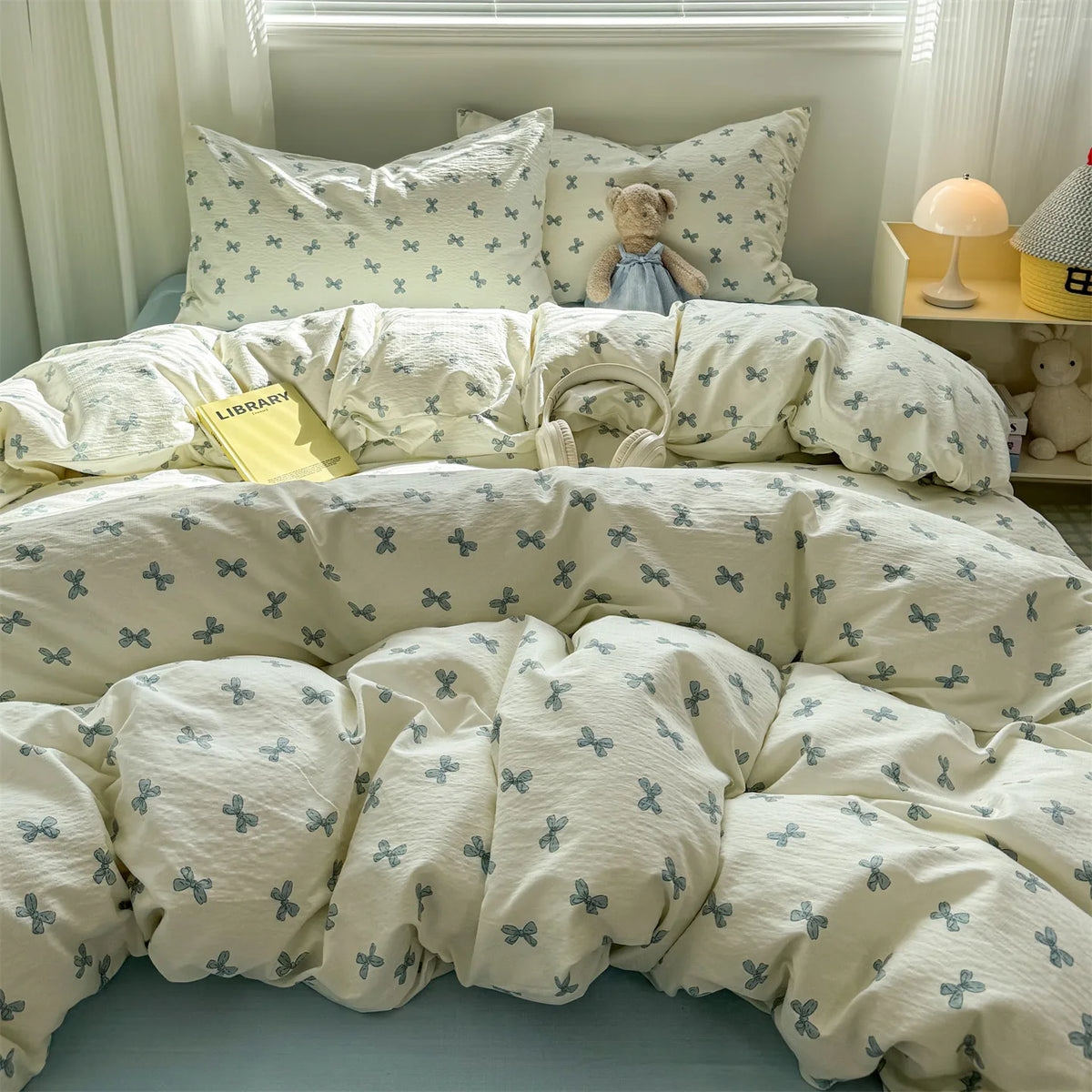 A white floral microfiber duvet set with blue accents is displayed on a bed, featuring a patterned cover and pillows.