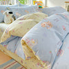 A light blue duvet and pillow set featuring a pattern of pink and yellow animals on a white background.
