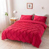 A vibrant red 3D pinch pleated duvet cover set displayed on a bed in a bright room.