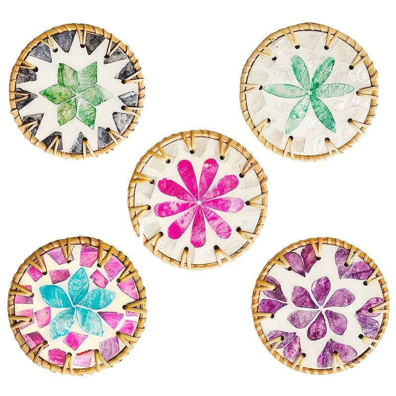 A set of five decorative woven shell coasters featuring various floral patterns in green, pink, and purple on a light backgro