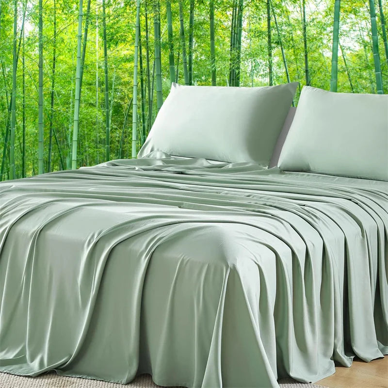 A luxury organic bamboo bed sheet set in sage green draped over a bed with a lush bamboo forest background.