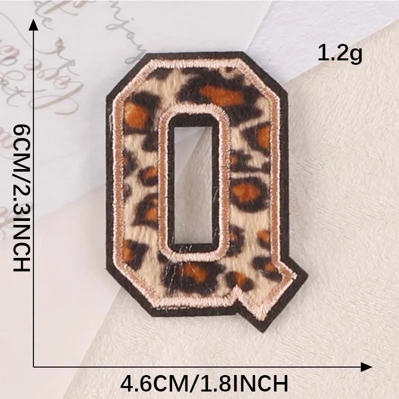 A leopard print iron-on patch shaped like the letter O, measuring 6cm high and 4.6cm wide.