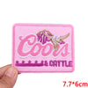Pink embroidered patch with the text Cools & Cattle in pink and gold thread
