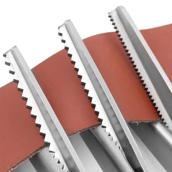 Close-up of stainless steel zig zag lace sewing scissors with a reddish fabric background.