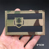 A rectangular tactical flag patch featuring a camouflage background and a shield emblem on a dark fabric.