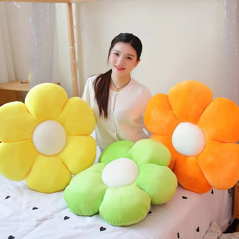 A collection of large plush flowers in yellow, orange, and green colors displayed on a white surface.
