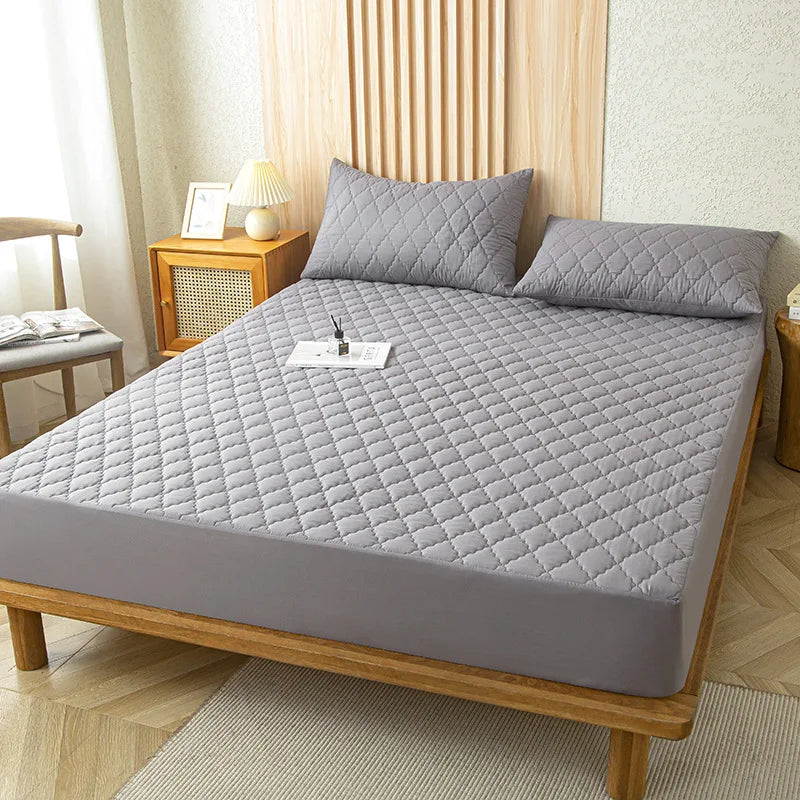 A gray waterproof mattress protector fitted sheet placed on a wooden bed frame.