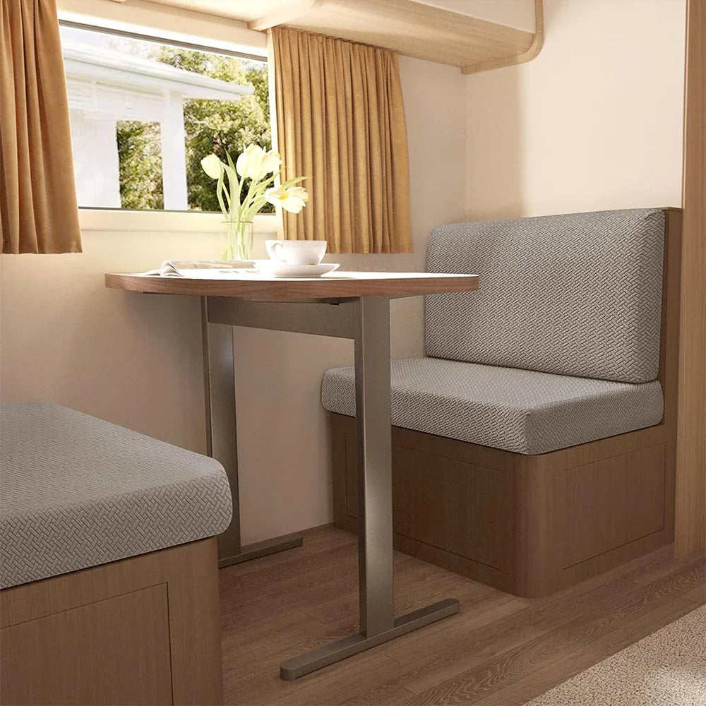 A beige upholstered seat cover is shown on a vehicle seat, with a wooden table and window in the background.