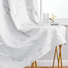 White curtain fabric featuring a marble print and silver stamping draped over a gold stand.