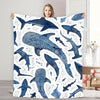 A plush blanket featuring a watercolor pattern of various whale sharks in shades of blue and white.