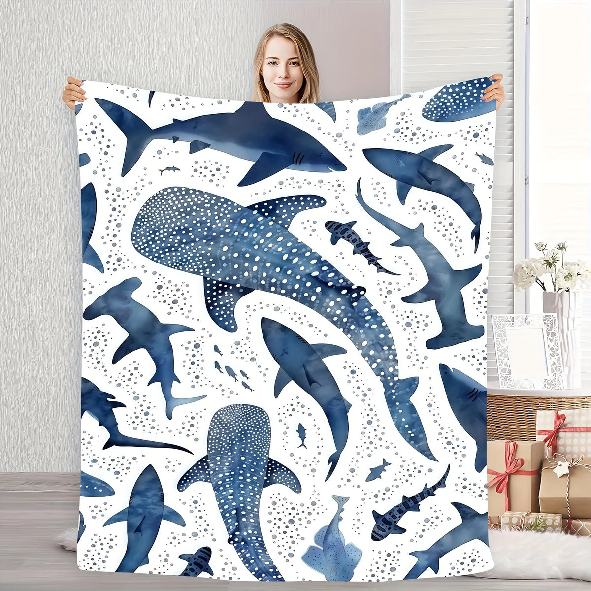 A plush blanket featuring a watercolor pattern of various whale sharks in shades of blue and white.