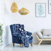 A deep blue fleece blanket with white text hangs on a wooden chair in a bright room.