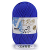 A skein of bright blue milk cotton yarn with a label in Chinese and English.