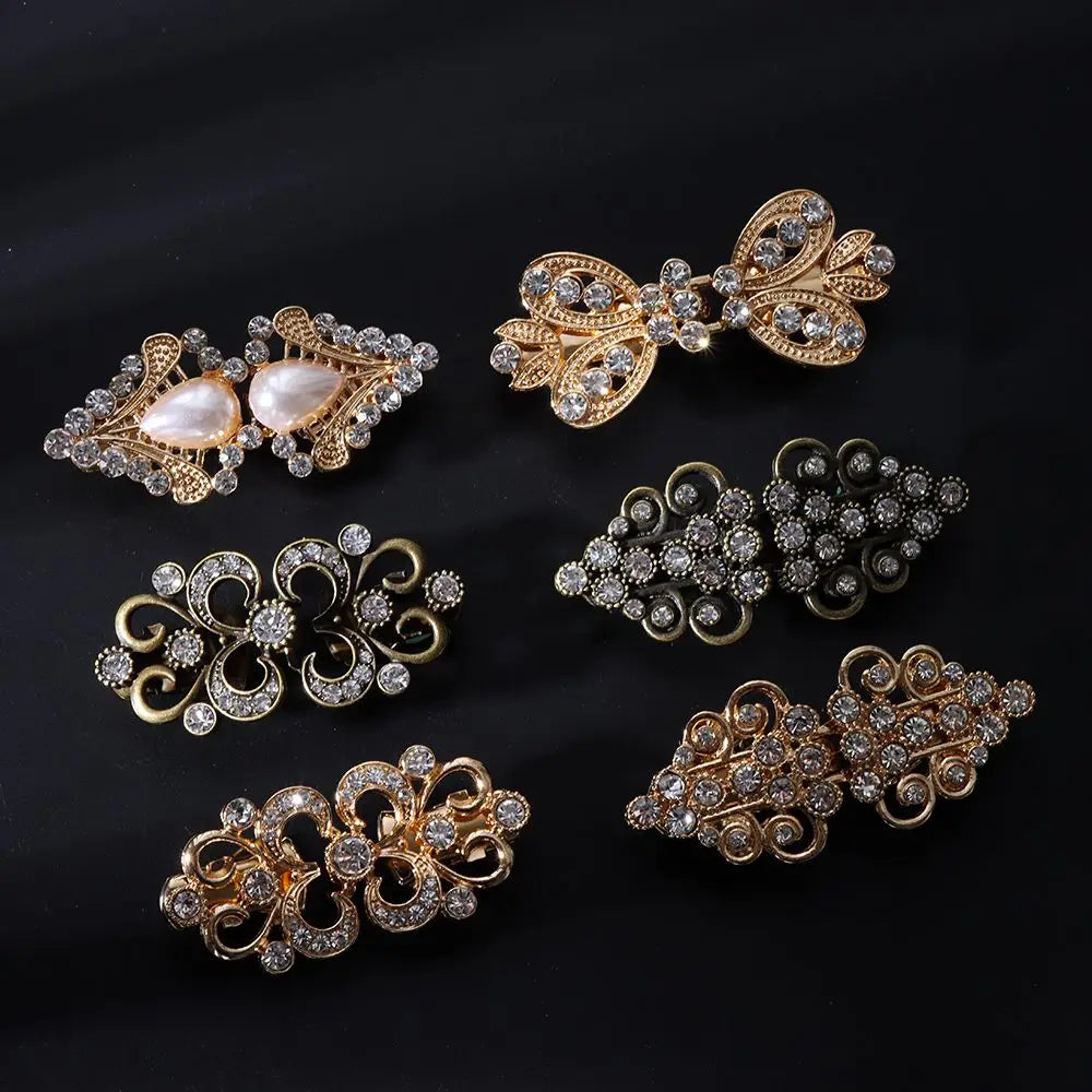 A collection of vintage gold and silver swirl clip brooches for scarves and clothing.
