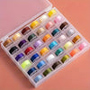 A plastic box filled with various colored pre-wound sewing machine bobbins for hand sewing.