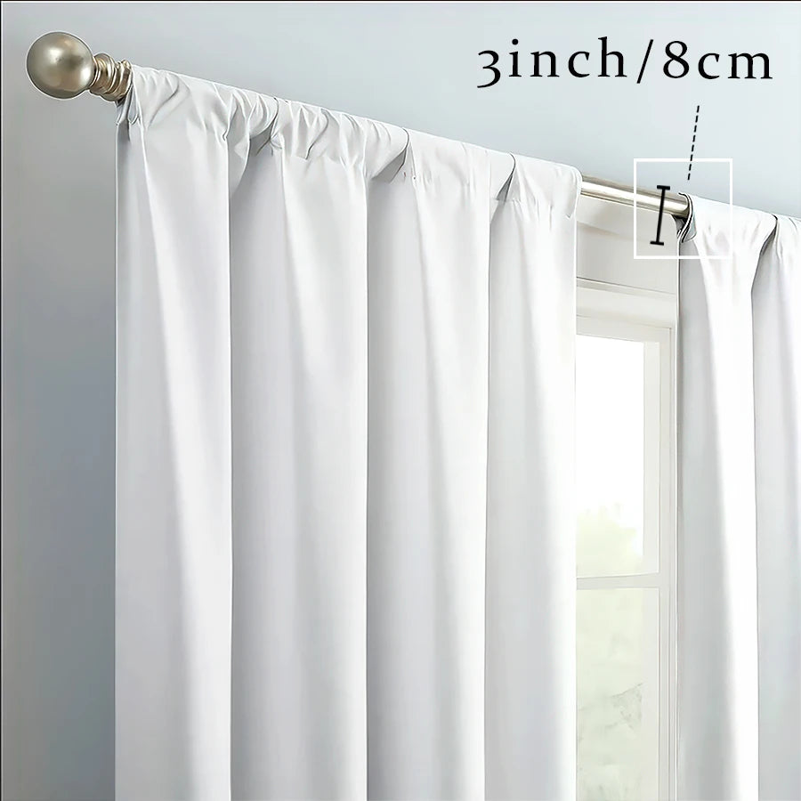 White curtain panels with champagne gold hardware and floral accents hanging in a window.