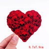 Red embroidery patch shaped like a heart filled with black skull designs