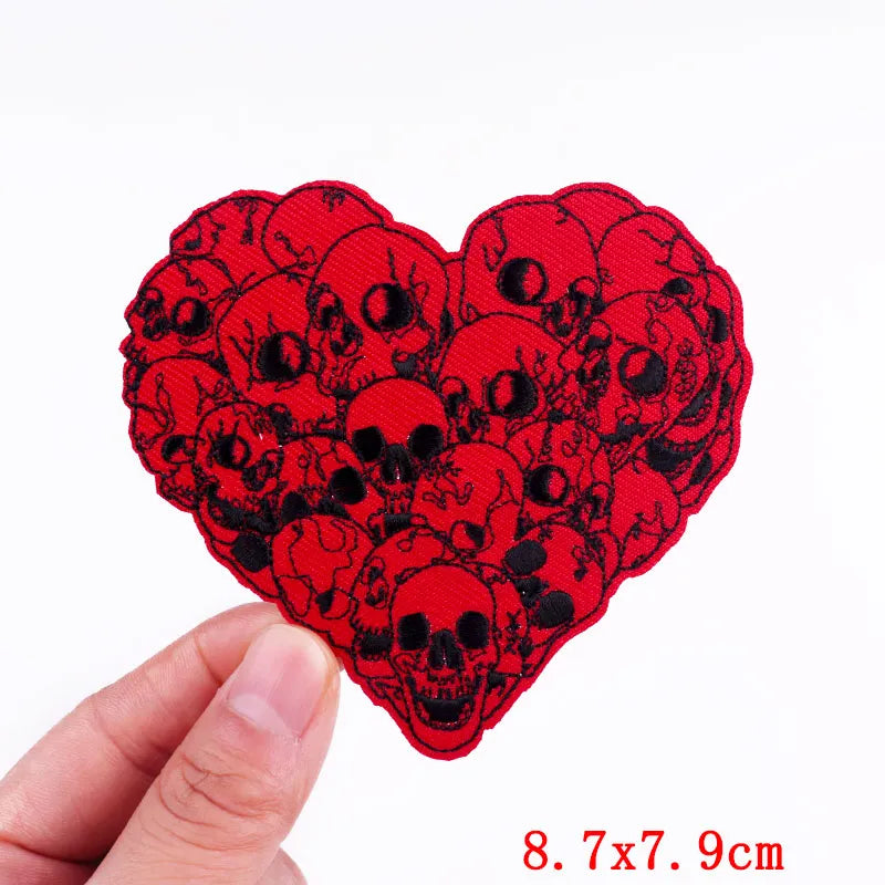 Red embroidery patch shaped like a heart filled with black skull designs
