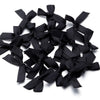 A pile of black satin ribbon bows for craft and decoration.