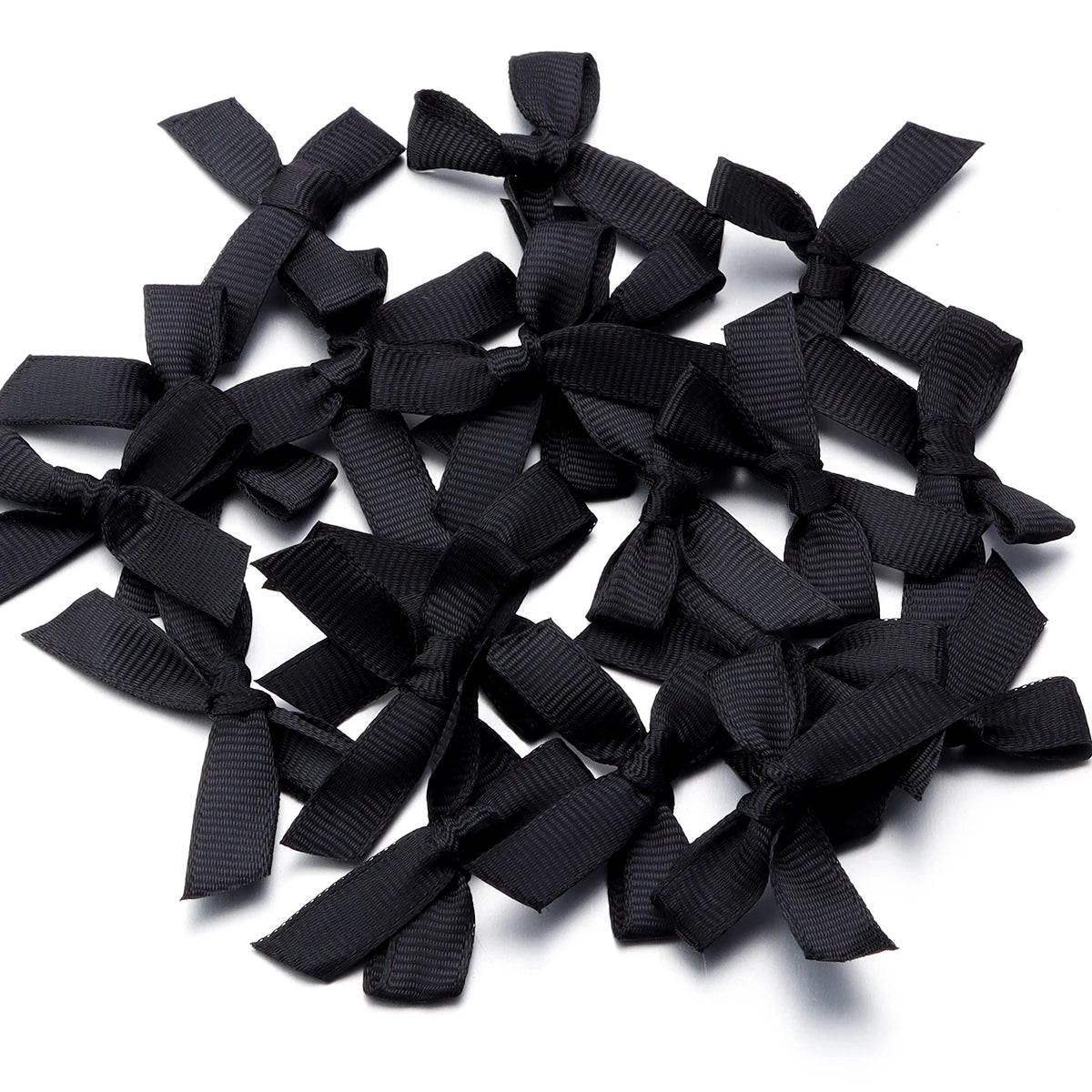 A pile of black satin ribbon bows for craft and decoration.