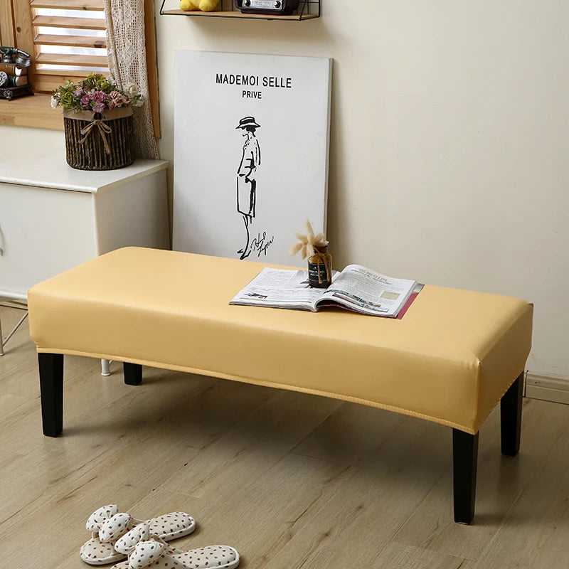 A yellow waterproof stretch dining bench cover is displayed on a wooden bench in a bright room.