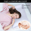 A woman rests her head on a white pillow with a pink satin shirt, demonstrating a comfortable sleep product.