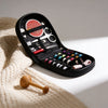 A black multi-functional sewing kit with various tools and threads is displayed on a cream knitted fabric.