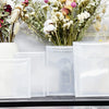 Clear plastic cutting dies for fruit and flower shapes displayed on a black shelf.