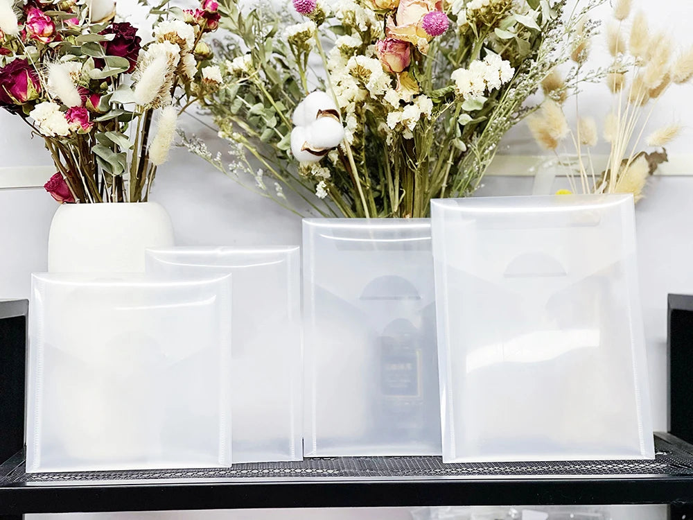 Clear plastic cutting dies for fruit and flower shapes displayed on a black shelf.