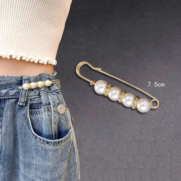 A gold-toned adjustable pearl brooch with seven white pearls is shown against a denim background.