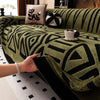 A close-up of a vintage bohemian knit sofa protector in olive green with black geometric patterns.
