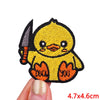 A yellow embroidered cartoon chick patch with black details being held by a hand.