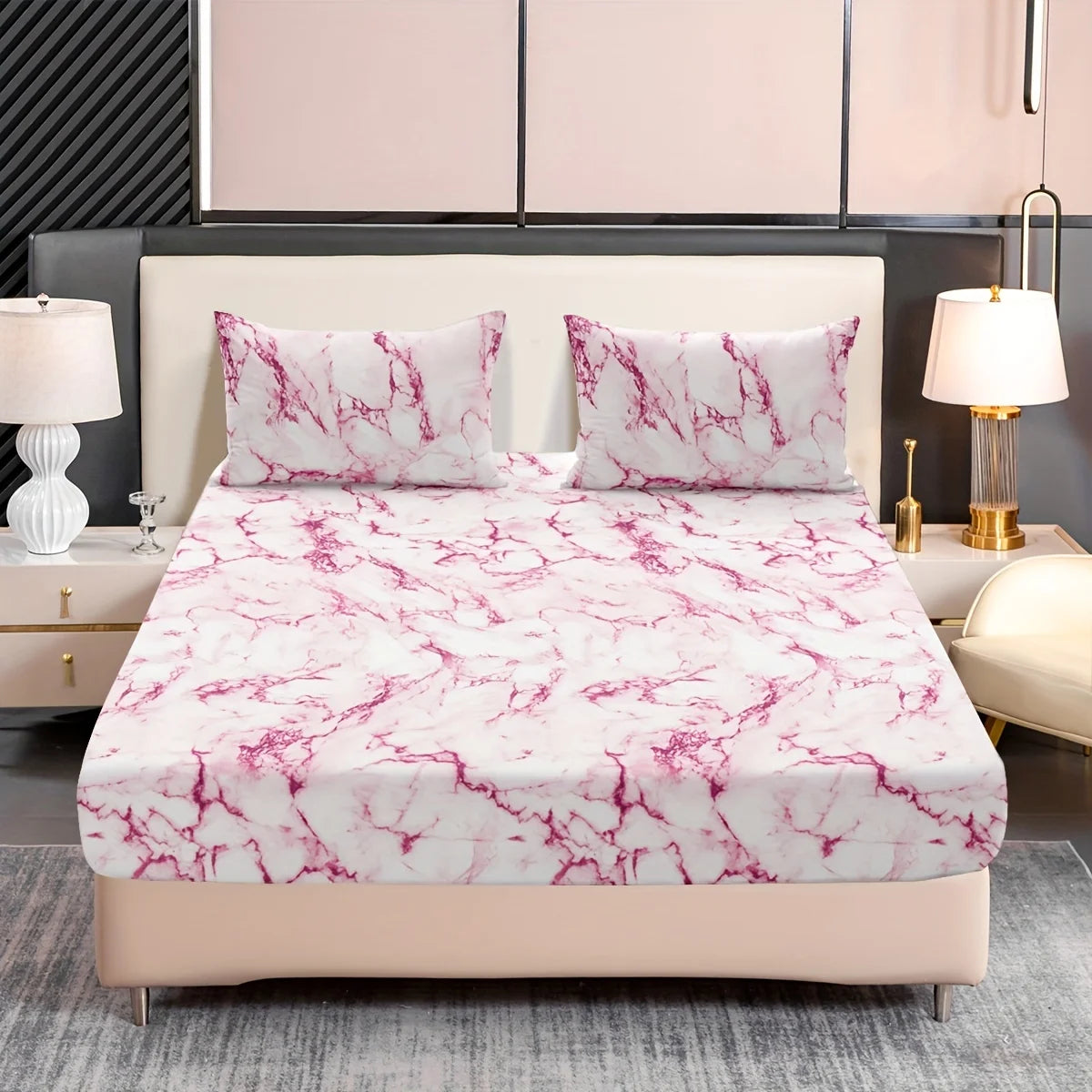 A pink and white marble print fitted sheet set with matching pillowcases displayed on a bed.