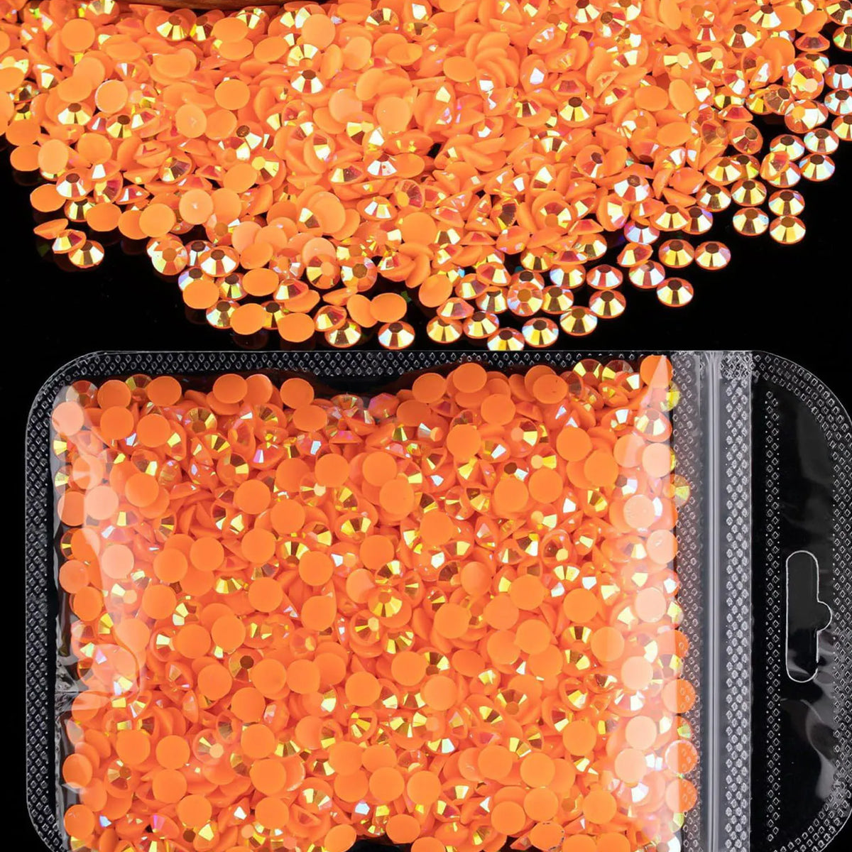 A pile of orange-red AB resin flatback rhinestones for crafts and nail art.